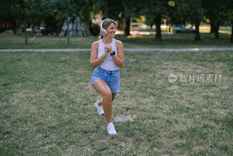 一位年轻女子正在公园里准备晨练。