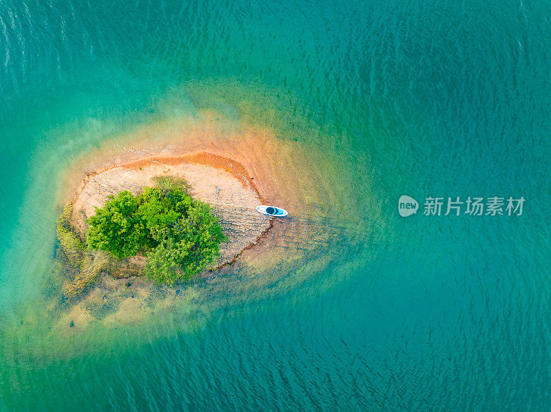 在蔚蓝的湖面上俯瞰小岛，进行SUP桨板运动