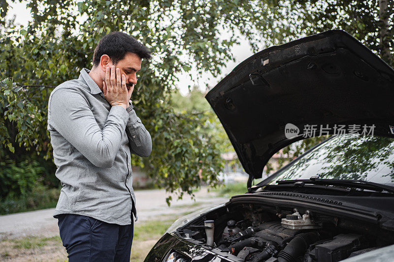 担心的白人男子试图修理他的汽车故障后