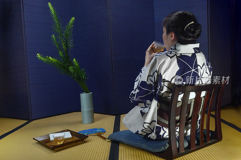 在日本传统房间里喝绿茶的女人