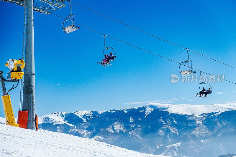 滑雪缆车在白雪皑皑的山峰和山坡上，晴朗的晴天