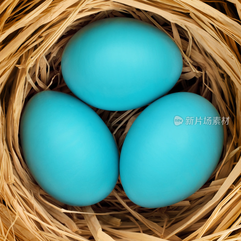 稻草上有三个蓝色的复活节彩蛋