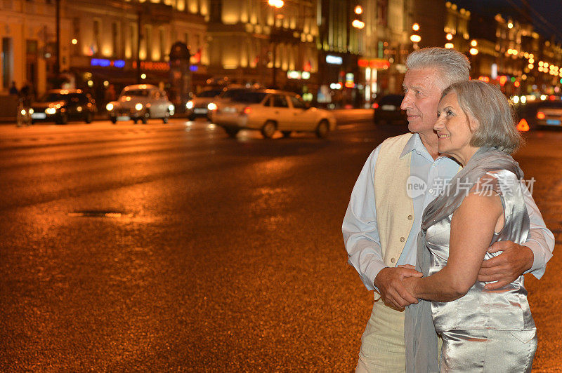 一对老年夫妇在夜晚的街道上