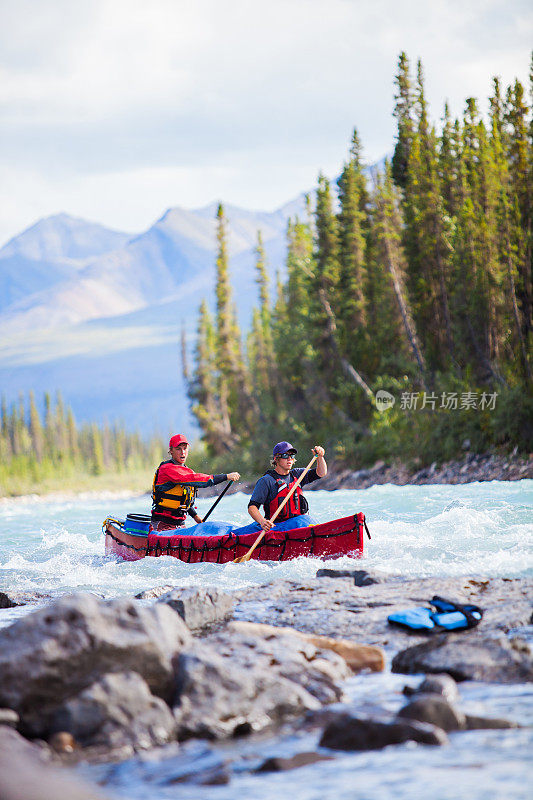 两个年轻人在加拿大北部的一条河里划船