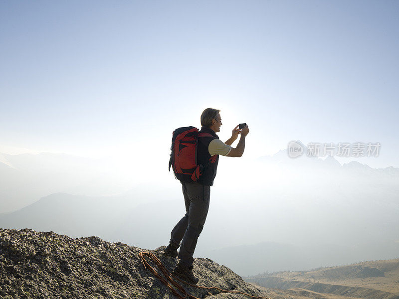 登山者站在山顶拍照