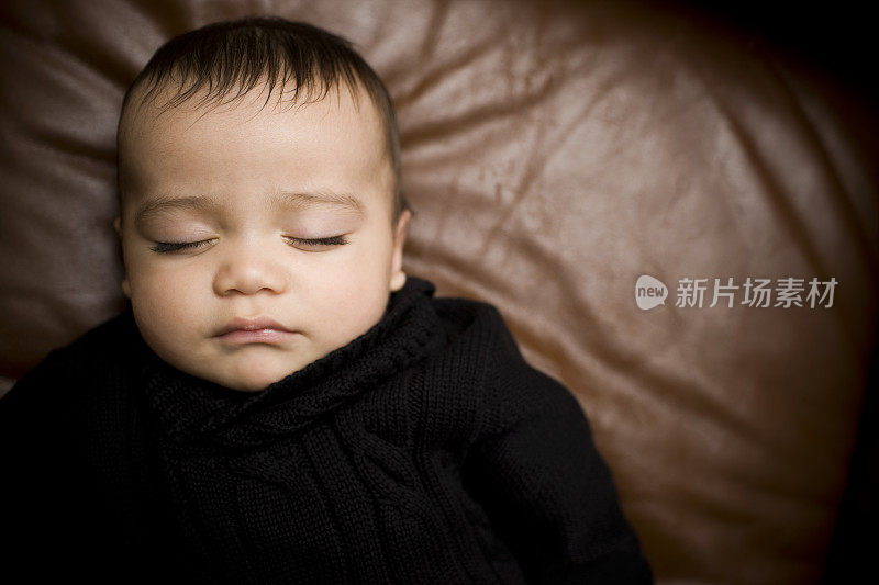 可爱的西班牙男婴肖像睡在沙发上，正上方