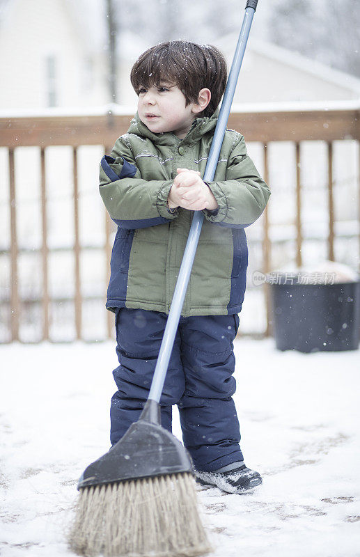 小男孩在清理桌子上的雪