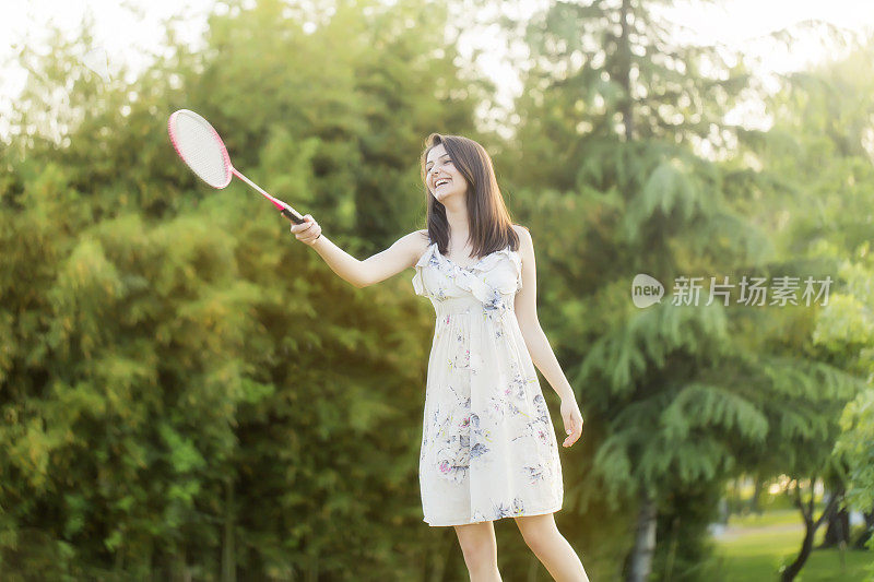 女子打羽毛球对夏季城市公园。