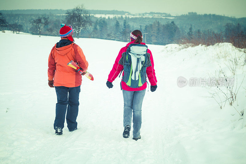 两个女性朋友在雪天徒步旅行