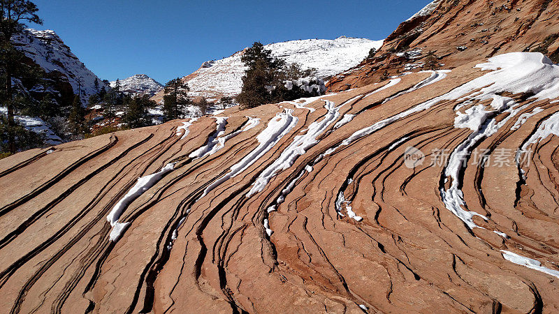 犹他州锡安的纳瓦霍砂岩层和积雪覆盖的山峰