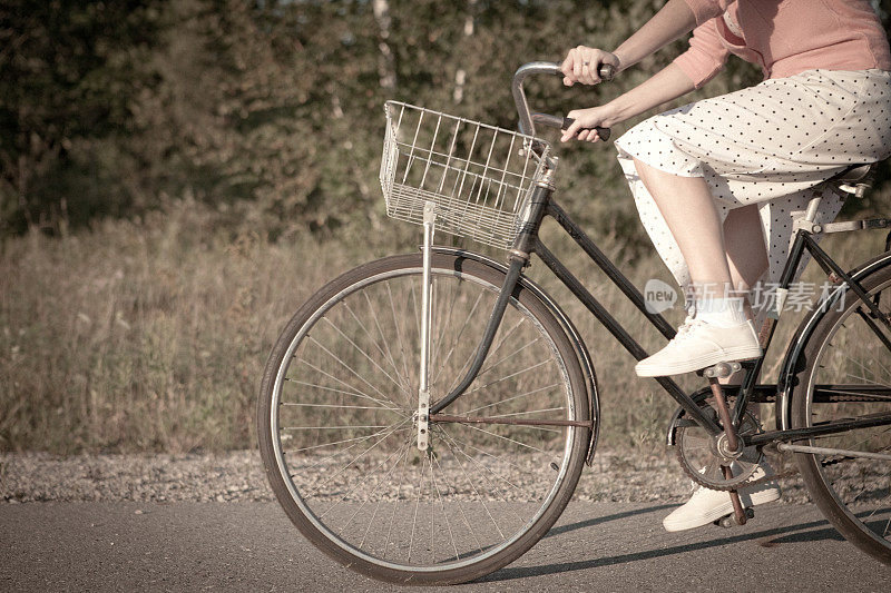 复古女孩骑着老式自行车在乡村路上