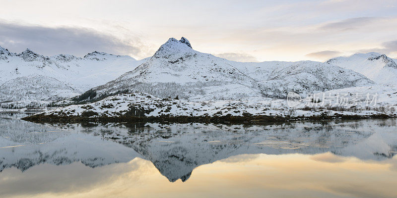 在挪威罗浮敦一个平静的冬湖上的日落