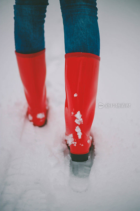 女徒步旅行者背包和雪鞋在雪地上的雪鞋