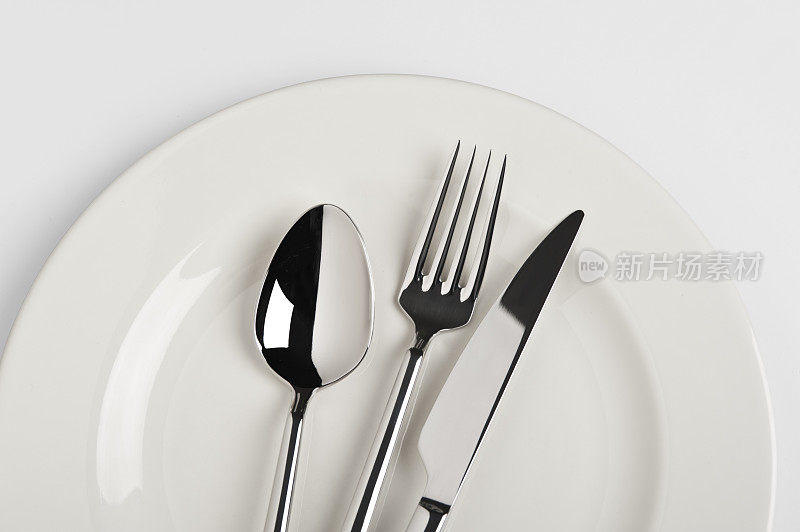 勺子，叉子和餐刀放在盘子里