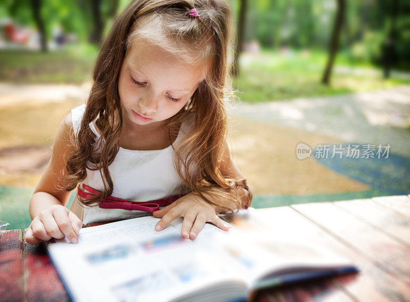小女孩在公园里看书
