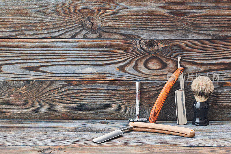 木制背景上的老式理发店工具