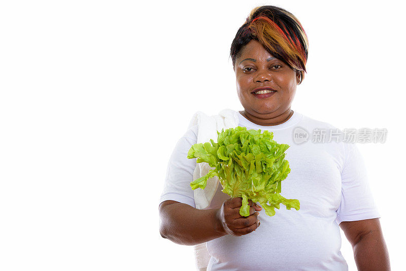 片场拍摄的一名非洲大码黑人妇女微笑着拿着生菜