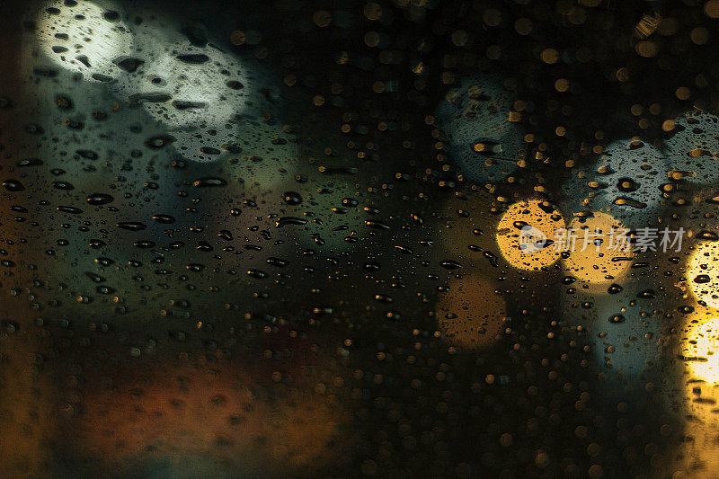 夜晚城市灯光背后的雨窗