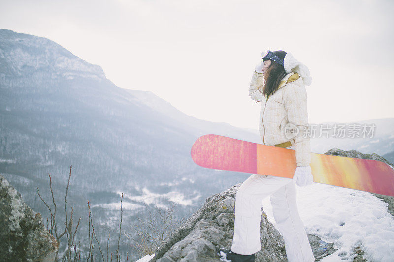 冬天穿着滑雪服的女人靠近滑雪板