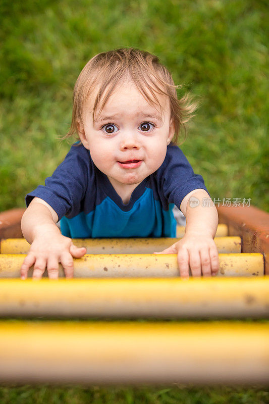 1岁男孩爬游乐场的梯子