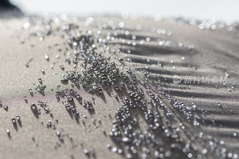 疏水性雨水水滴在防水遮阳伞表面形成小珠。