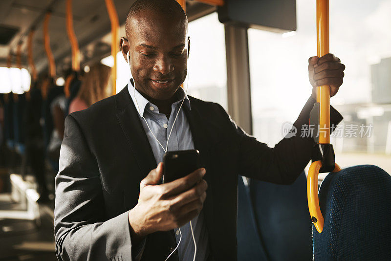 年轻的非洲商人坐在公交车上听着音乐