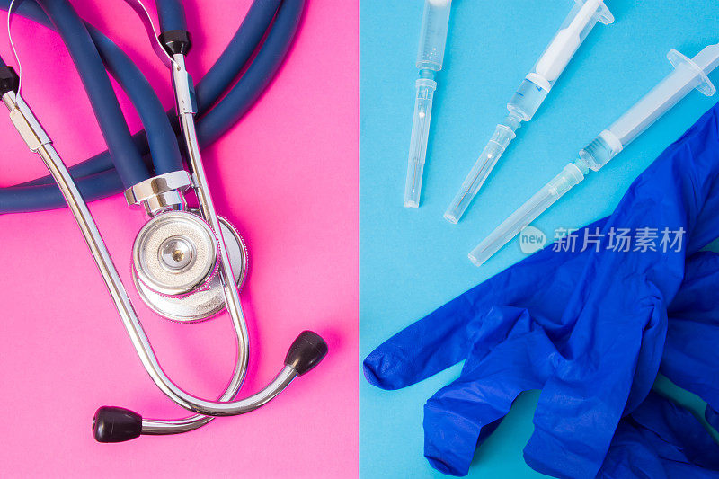 医用防护手套与带药物的注射器和医用听诊器并排放置，两种颜色背景:蓝色和粉色。治疗概念、医疗操作或护士工作
