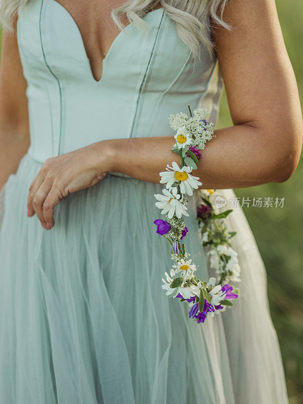 女人拿着她仲夏的花环