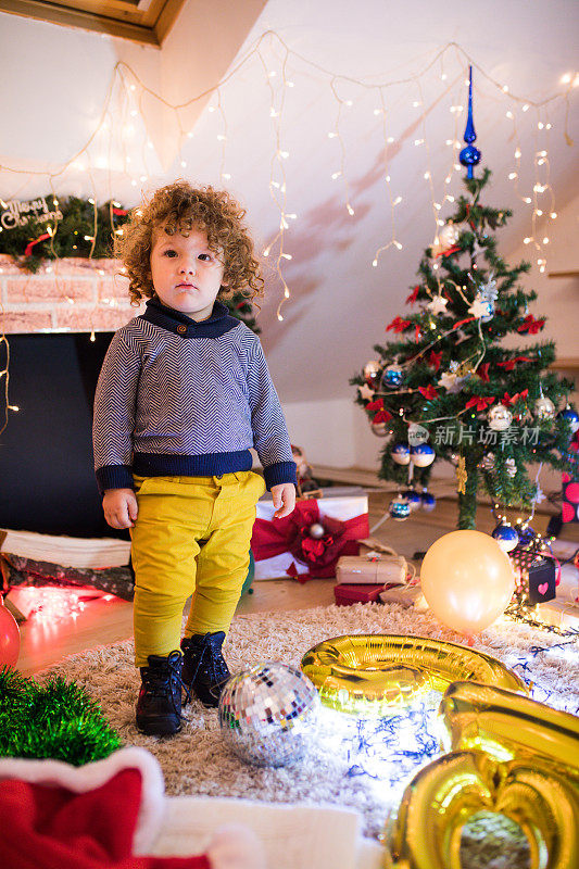 孩子在圣诞树和壁炉在圣诞夜。
