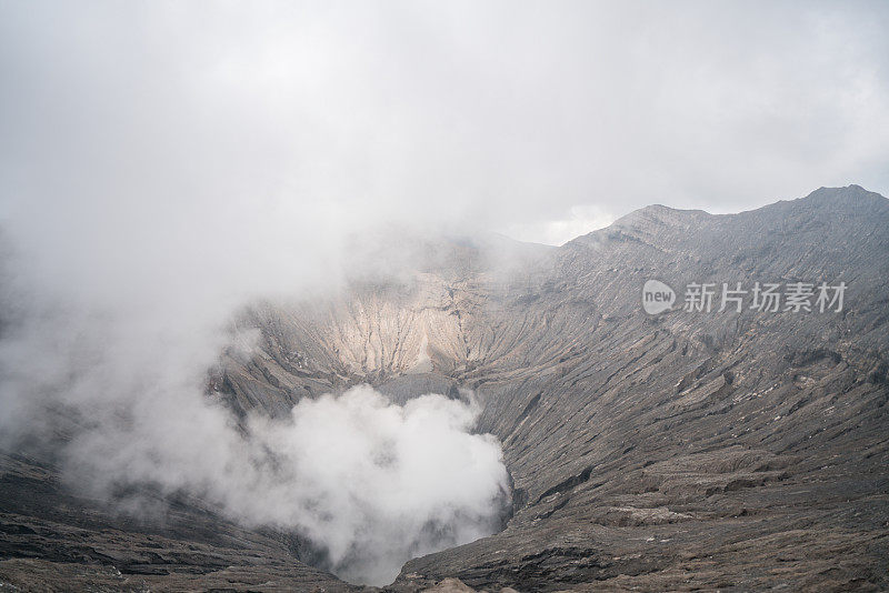 在印度尼西亚东爪哇岛的布罗莫山国家公园，布罗莫火山口边缘有蒸汽。旅游目的地冒险的自然概念