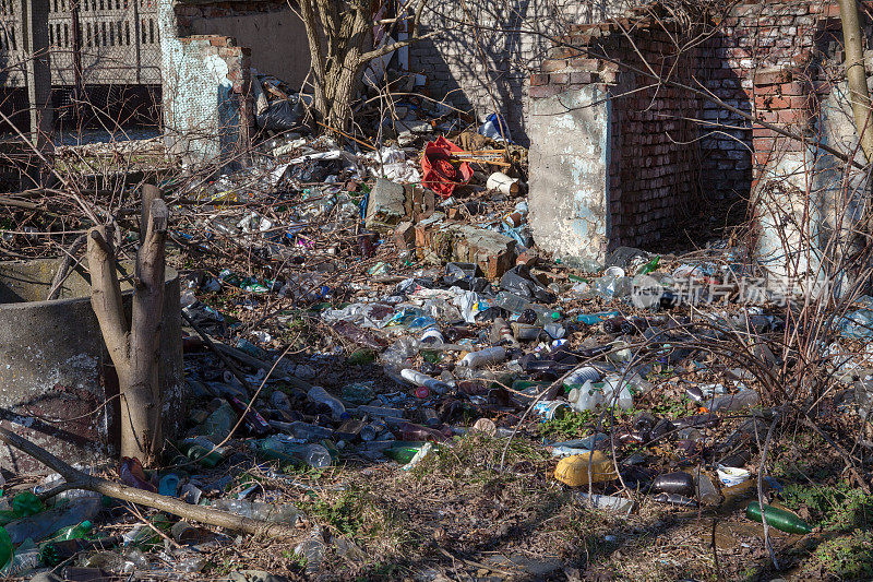 在废弃的土地上丢弃的玻璃和塑料垃圾