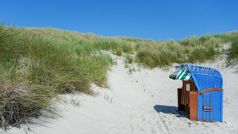 蓝色沙滩椅在阳光下的沙丘和晴朗的蓝天在岛上Hel?goland杜恩，德国海滩