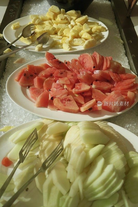 欧式酒店自助餐厅早餐水果拼盘的图片:切片的甜瓜和新鲜的菠萝块加碎冰块，西瓜，gala和哈密瓜食谱，健康的水果沙拉图片，木瓜和一天五份