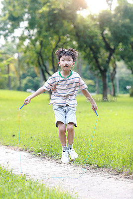 小男孩在草地上跳绳