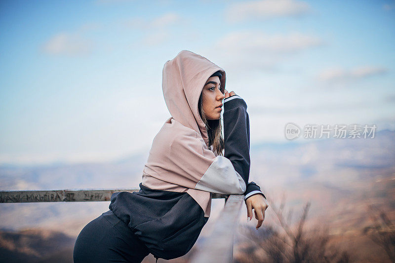 穿着运动服的年轻女子正在欣赏风景