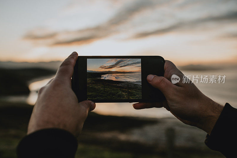 用智能手机拍摄日落时的大海