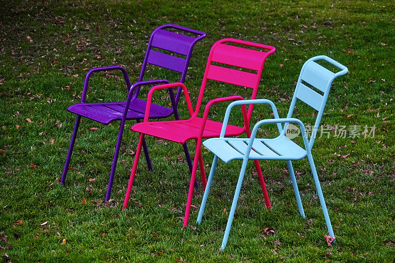 草地上的三把彩色椅子