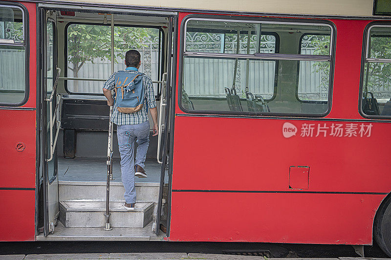 戴着耳机的年轻人正在上公交车