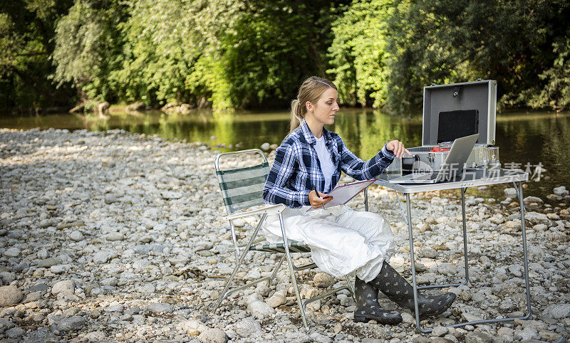 一位女性生态学家分析一条森林河流的水的状态