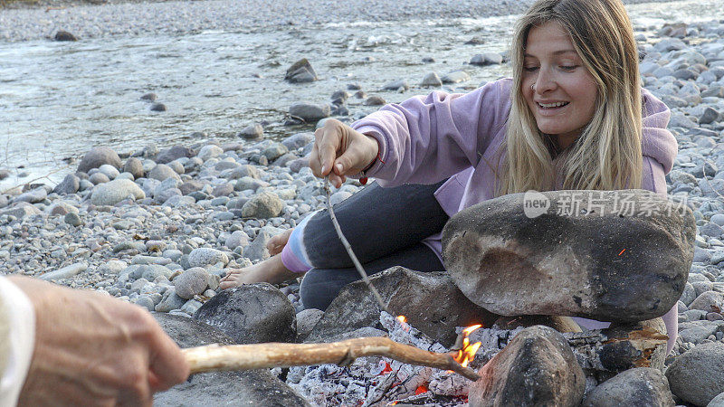 年轻女子在河湾玩火
