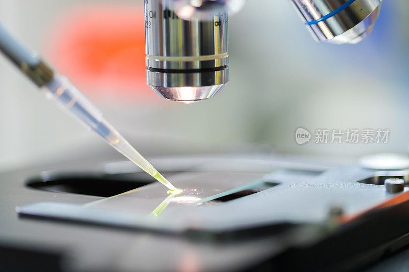 在显微镜下，科学家将化学液体滴在载玻片上的图片，概念科学和技术
