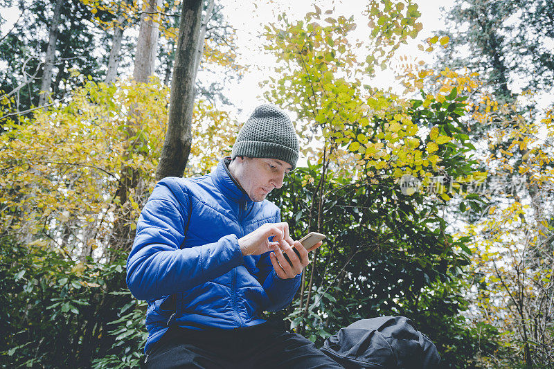 一名男子在登山时使用智能手机