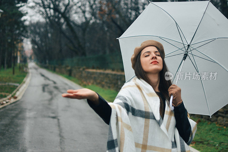 美丽的年轻女子享受着雨天