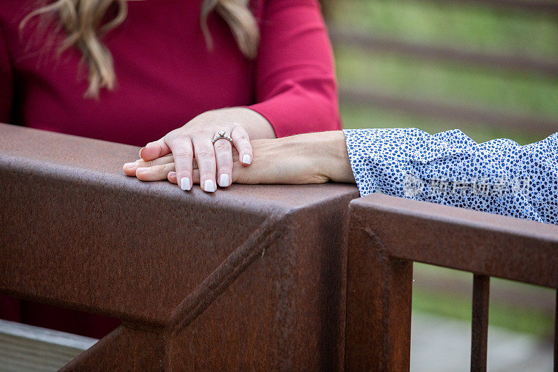 订婚的情侣将手放在对方身上炫耀订婚戒指