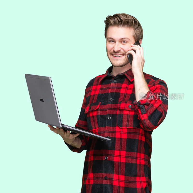 白人年轻男子站着穿衬衫用笔记本电脑