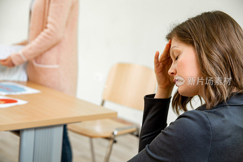 劳累过度的女人在商务会议上睡着了-库存照片