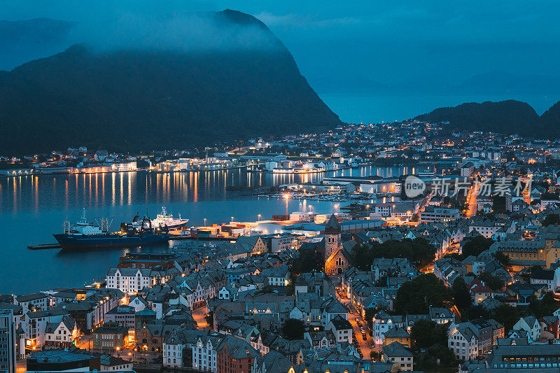 奥勒松,挪威。夜景的奥勒松天际线城市景观。夏夜的历史中心。著名的挪威地标和受欢迎的目的地。奥勒松，凯文观点，山