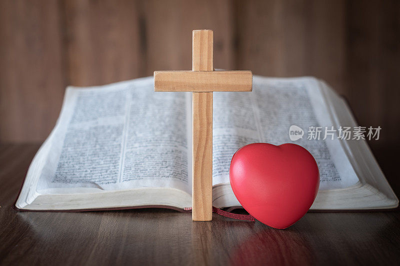 十字架和红心紧紧地放在一起。相信神的神圣能力，通过向他祷告，基督教，耶稣