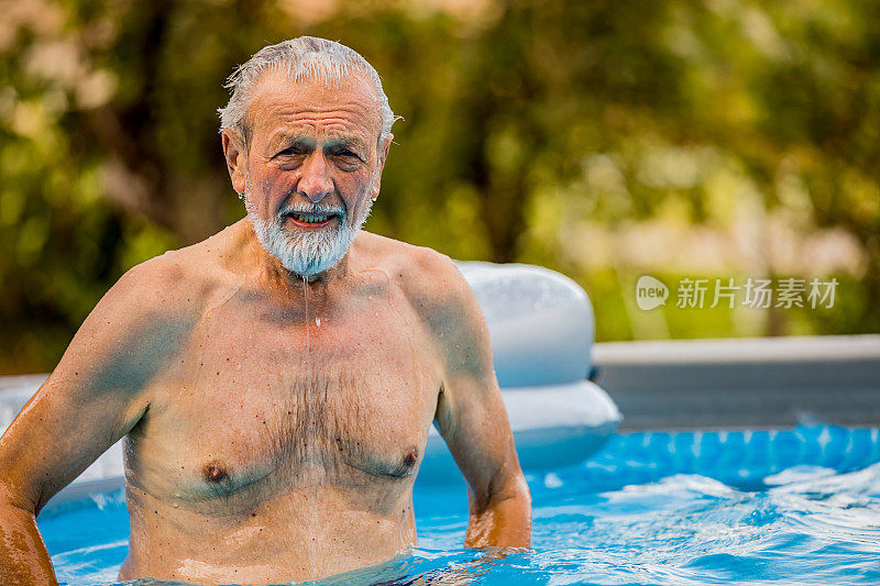 快乐健康的长者享受游泳池充气床的乐趣