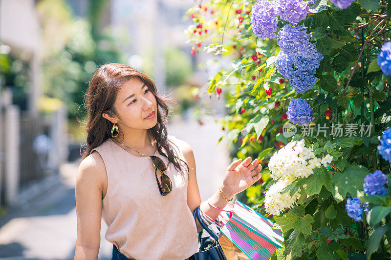 年轻女子在街上看绣球花